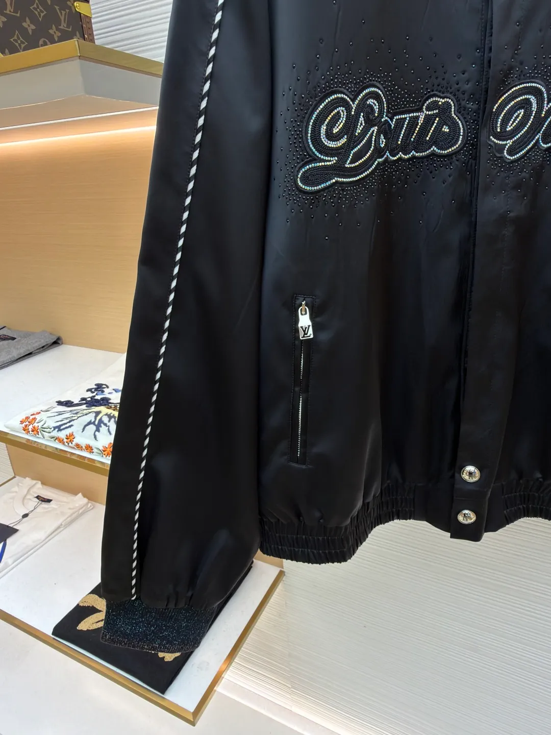 LOUIS VUITTON chest embroidered rhinestone jacket ●Original version: Purchased and developed at 22889 ●Item number: 1681600-B70 ●Material: 100% cotton ●Technology: rhinestone production ●Color: black ●Version: Fitted version ●Weight: about 740 grams ●Size: 46-48-50-52 ●Description: This Louis Vuitton jacket is made of high-quality black satin material, with a delicate texture and rich luster. The craftsmanship incorporates a variety of advanced production technologies: the eye-catching brand logo on the chest is combined with three-dimensional embroidery and hot-drilling technology. The stitching is precise and layered, highlighting the brand's unique recognition; the black and white braided belt decoration on the shoulders and sides not only increases the visual hierarchy, but also enhances the overall sense of fashion and sophistication. The neckline and cuffs are neatly cut and have smooth lines, showing a simple yet high-end style. The zipper and metal buckle have exquisite details and outstanding texture. Manual tile measurement, the error of 1-3CM is within the normal range, which is also the uniqueness of manual craftsmanship. Whether it is worn for daily wear or paired with a jacket, it can easily show fashionable taste and luxurious temperament. The overall wiring is straight and delicate, the fabric is comfortable and soft, and the color is consistent without color difference. It can be matched with the same style to create a fashionable look and control various occasions. Customized accessories, complete with three standards, same style for men and women!